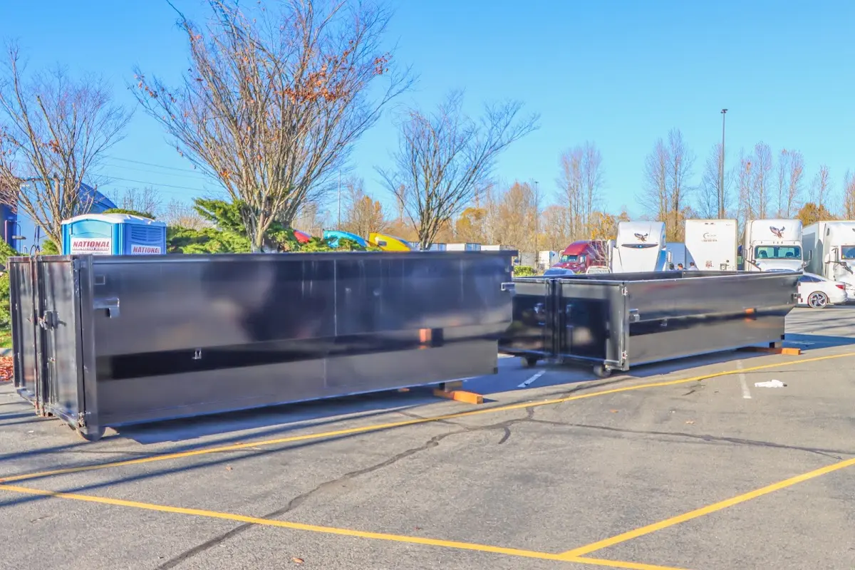 Professional dumpster rental service with roll-off container on residential driveway in Armada